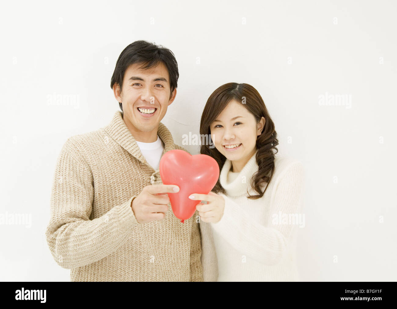 Couple Holding Heart Balloon Stock Photo - Alamy