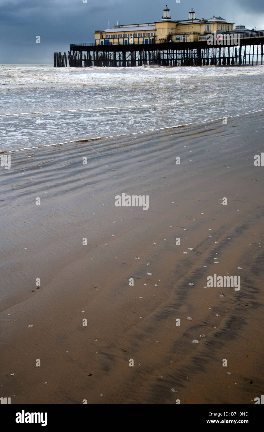 tide on the sandy shore on the Sussex coast with Hastings pier