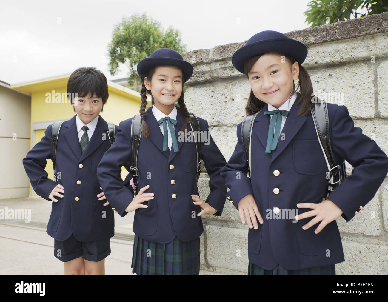 Elementary school students standing in front of school gate Stock Photo