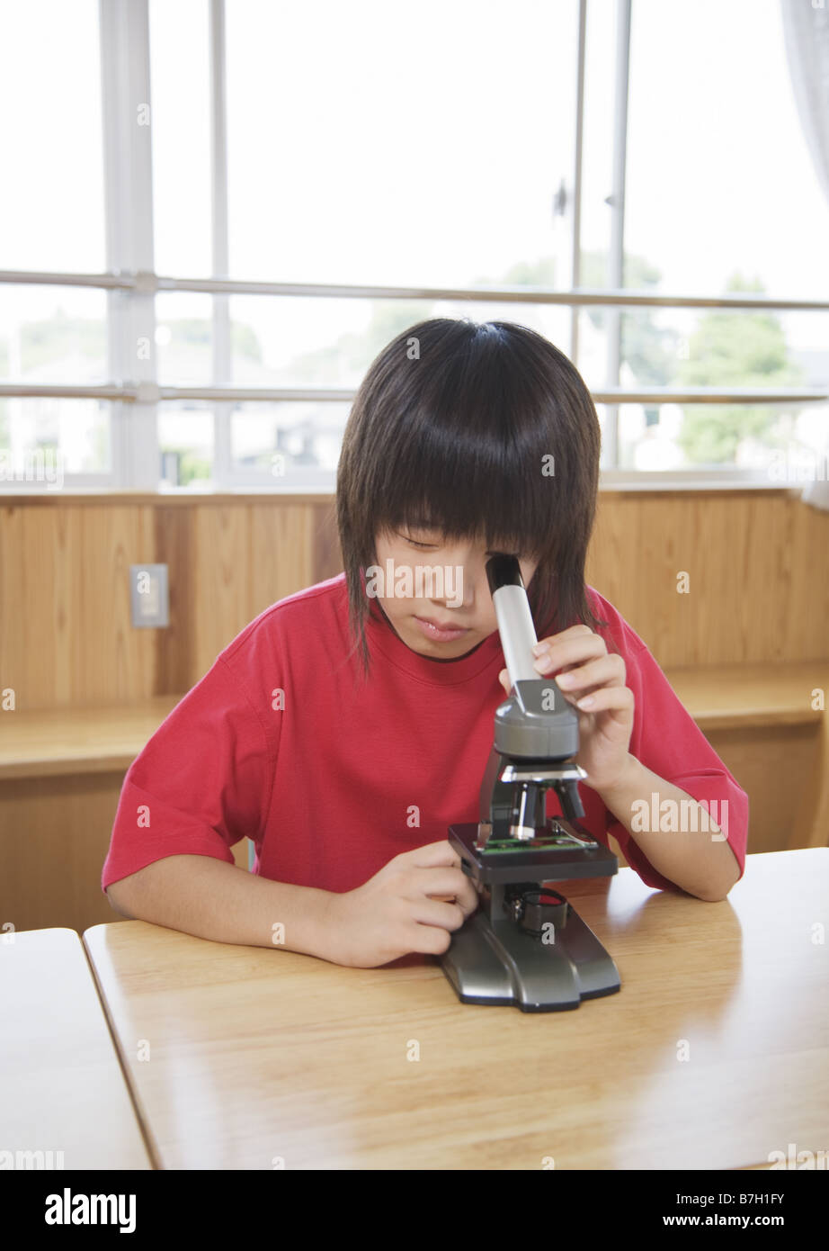 Elementary school student looking through a microscope Stock Photo Alamy