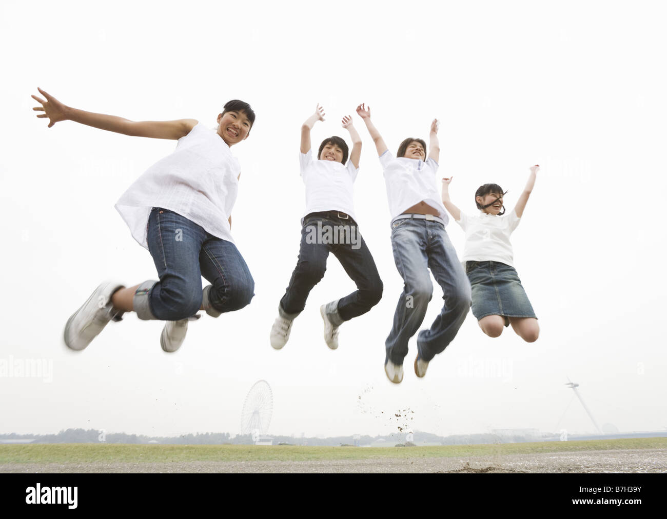 Jumping to the sky with good friends in the field Stock Photo - Alamy