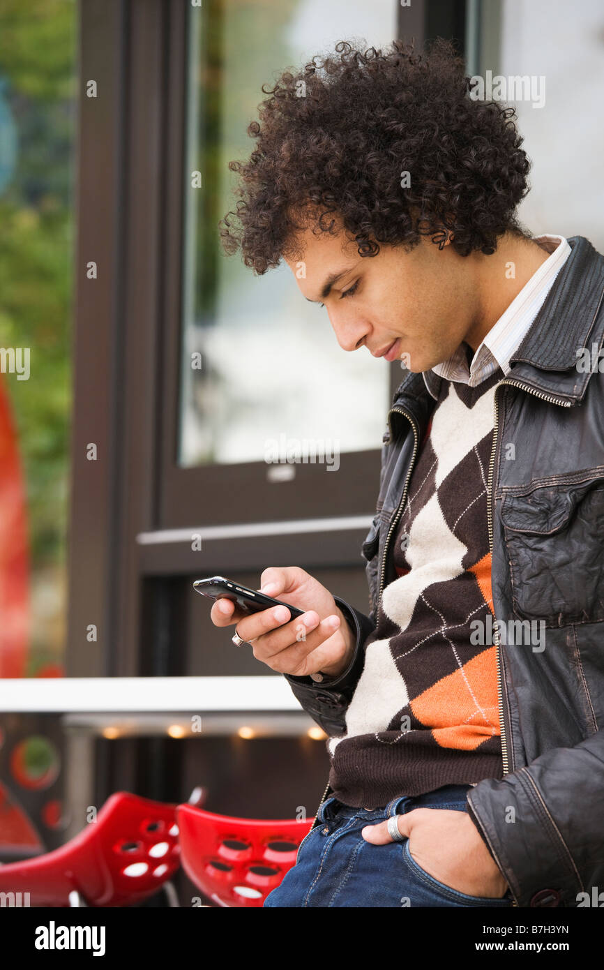 Middle Eastern man text messaging on cell phone Stock Photo