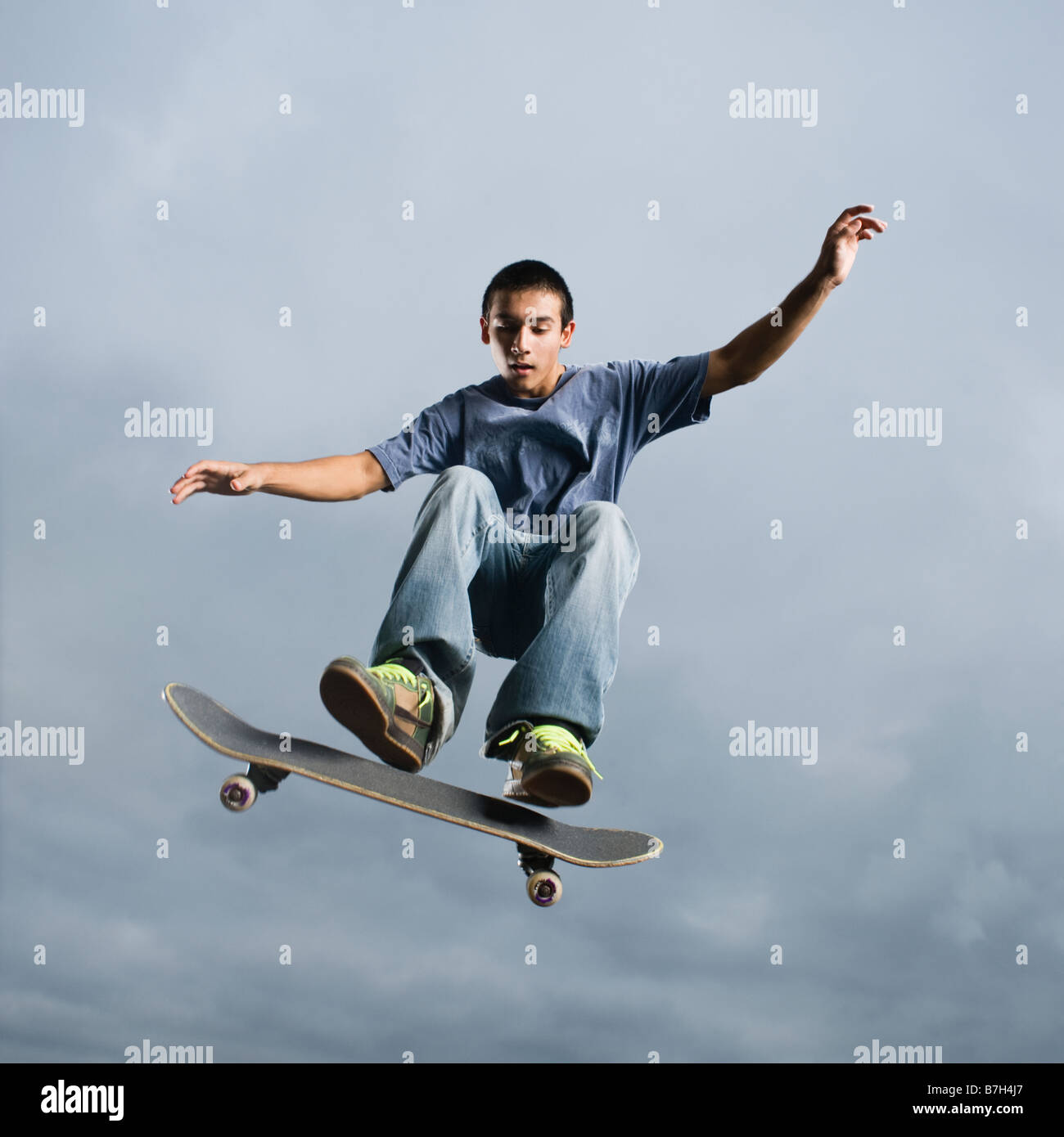 Mixed race teenager in mid-air on skateboard Stock Photo