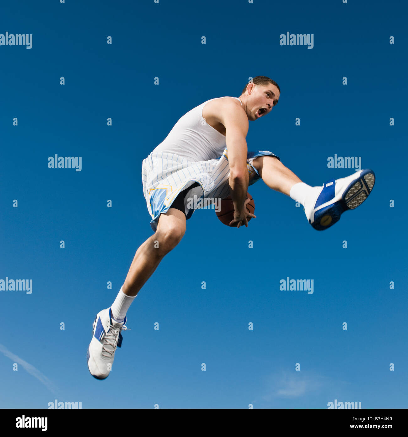 African man playing basketball in mid-air Stock Photo
