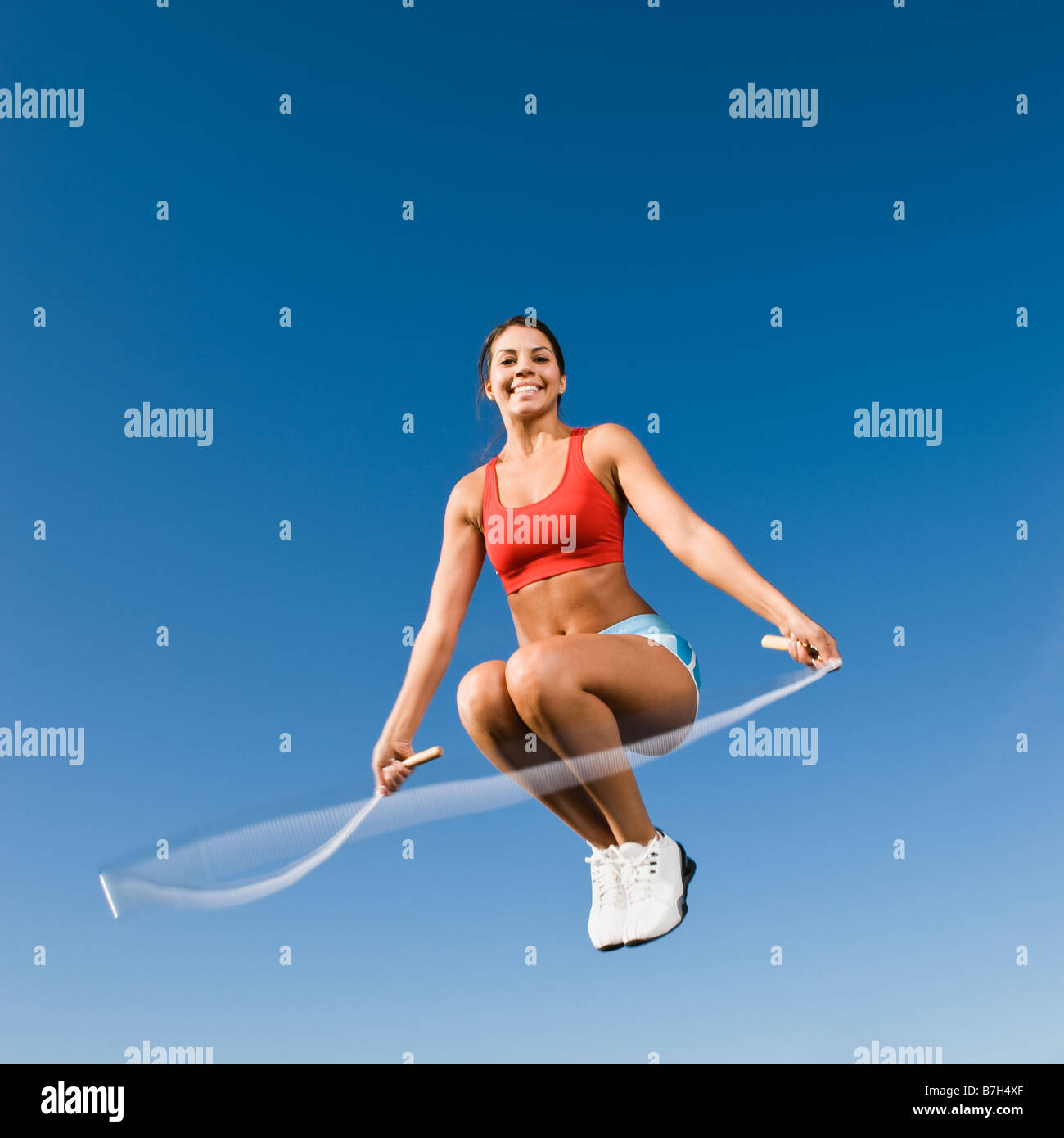 Native American woman jumping rope in mid-air Stock Photo
