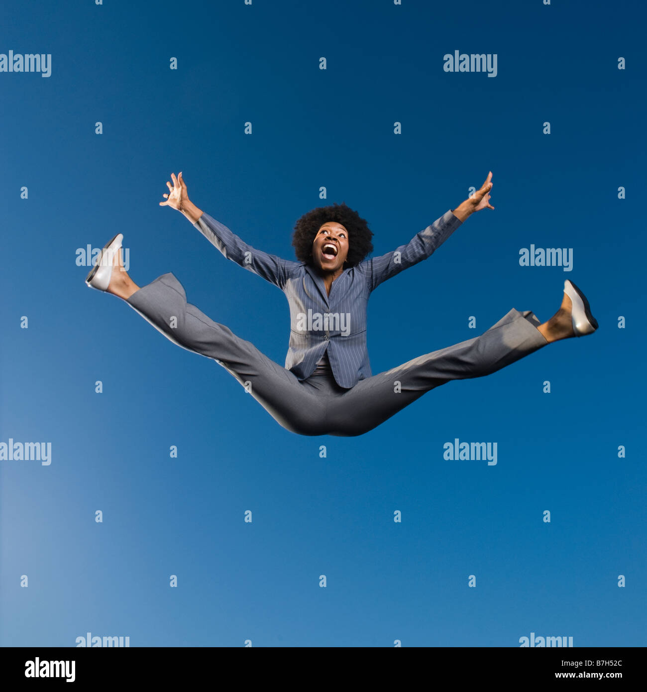 African businesswoman jumping in mid-air Stock Photo