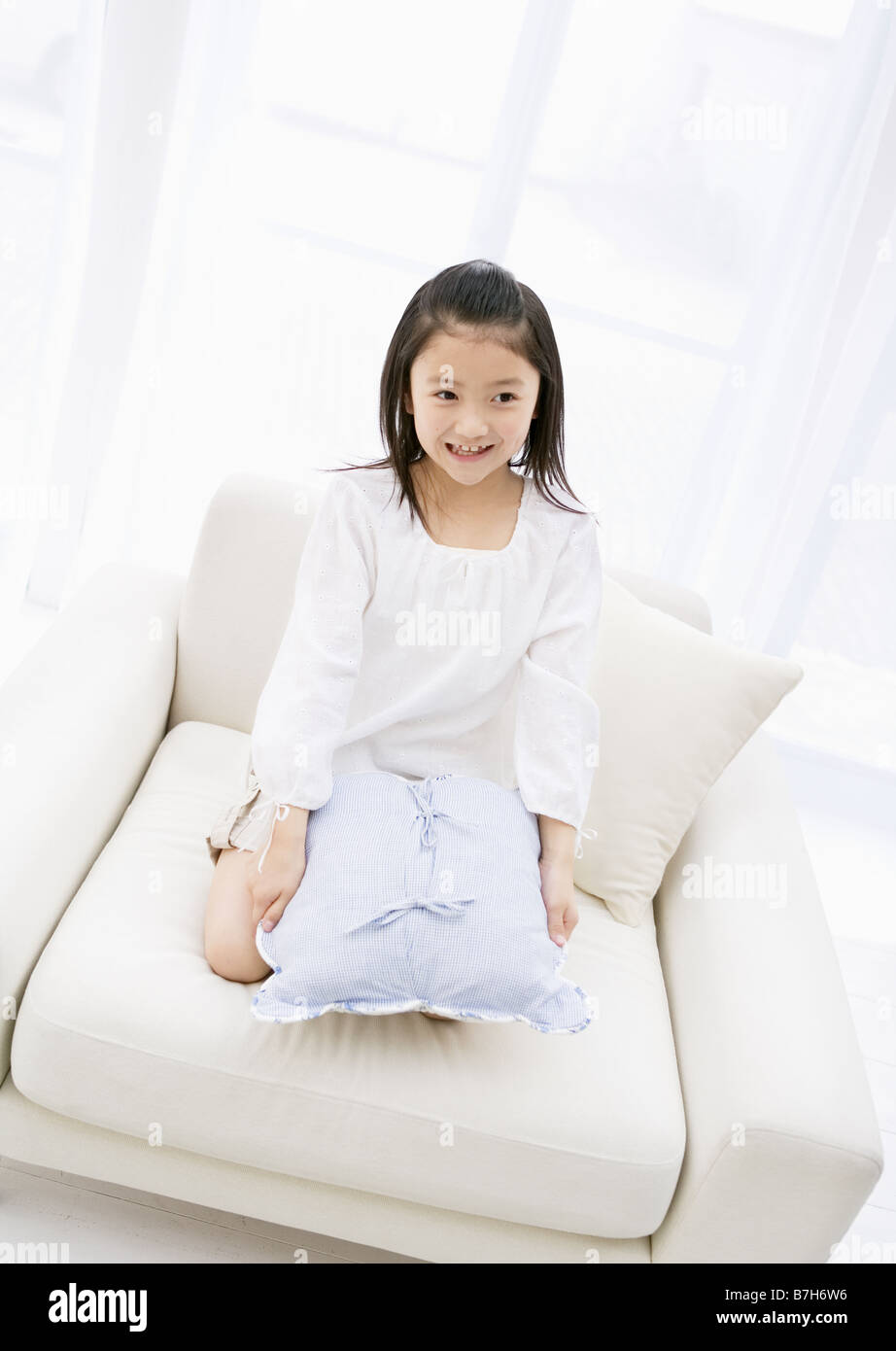 Girl Sitting on the Sofa Stock Photo - Alamy