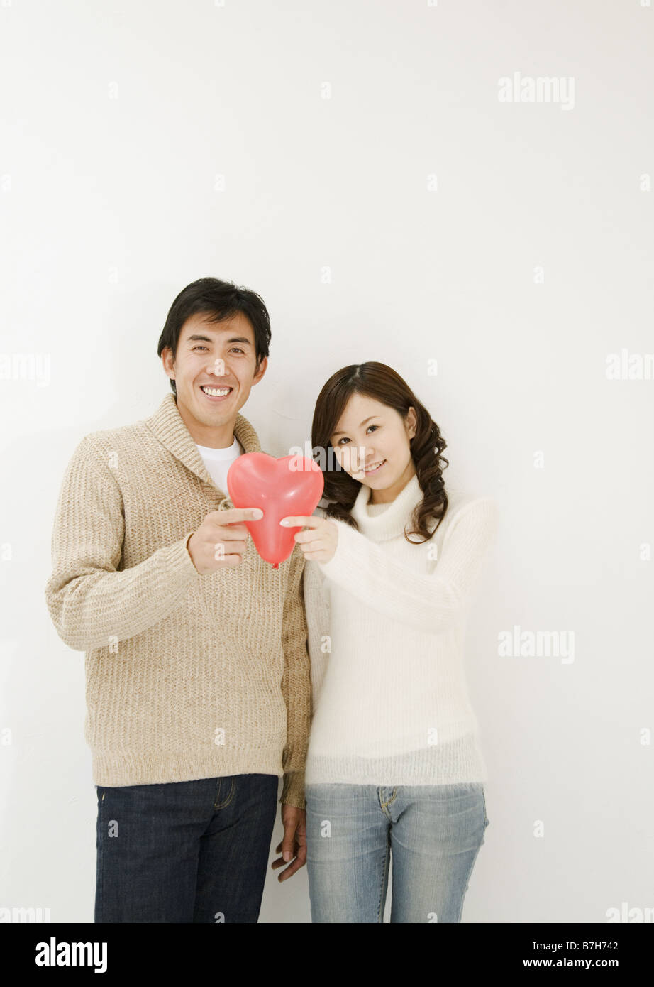 Couple Holding Heart Balloon Stock Photo - Alamy