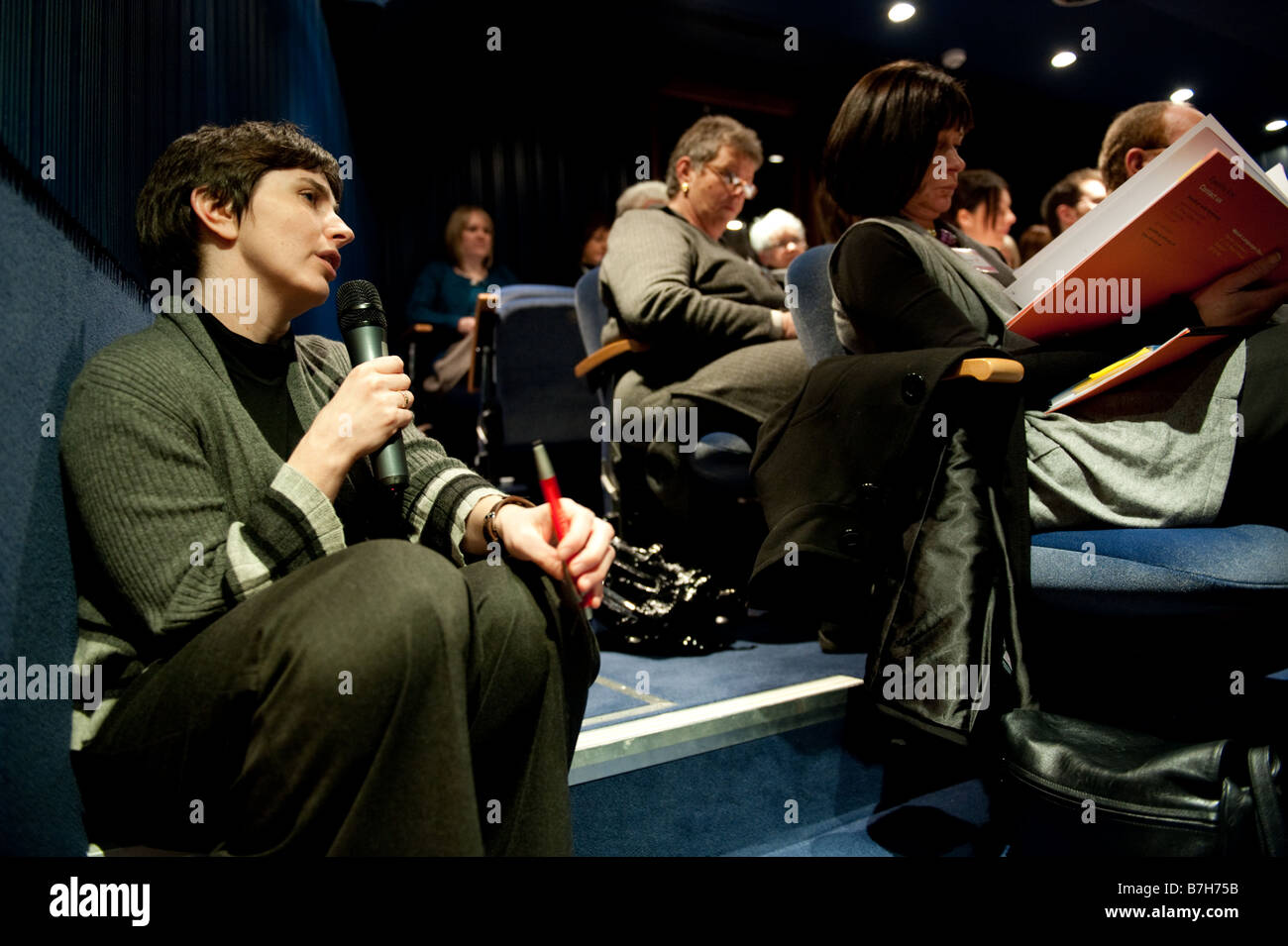 A woman holding microphone giving simultaneous translation at a welsh language conference at the National Library of Wales UK Stock Photo