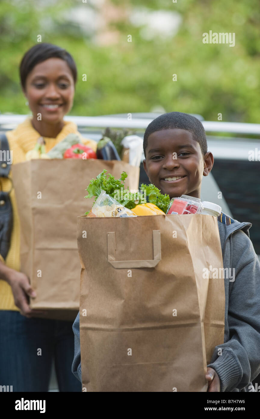 African boy helping mother unload groceries Stock Photo