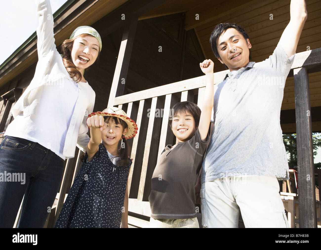 Family with arms raised in the air Stock Photo