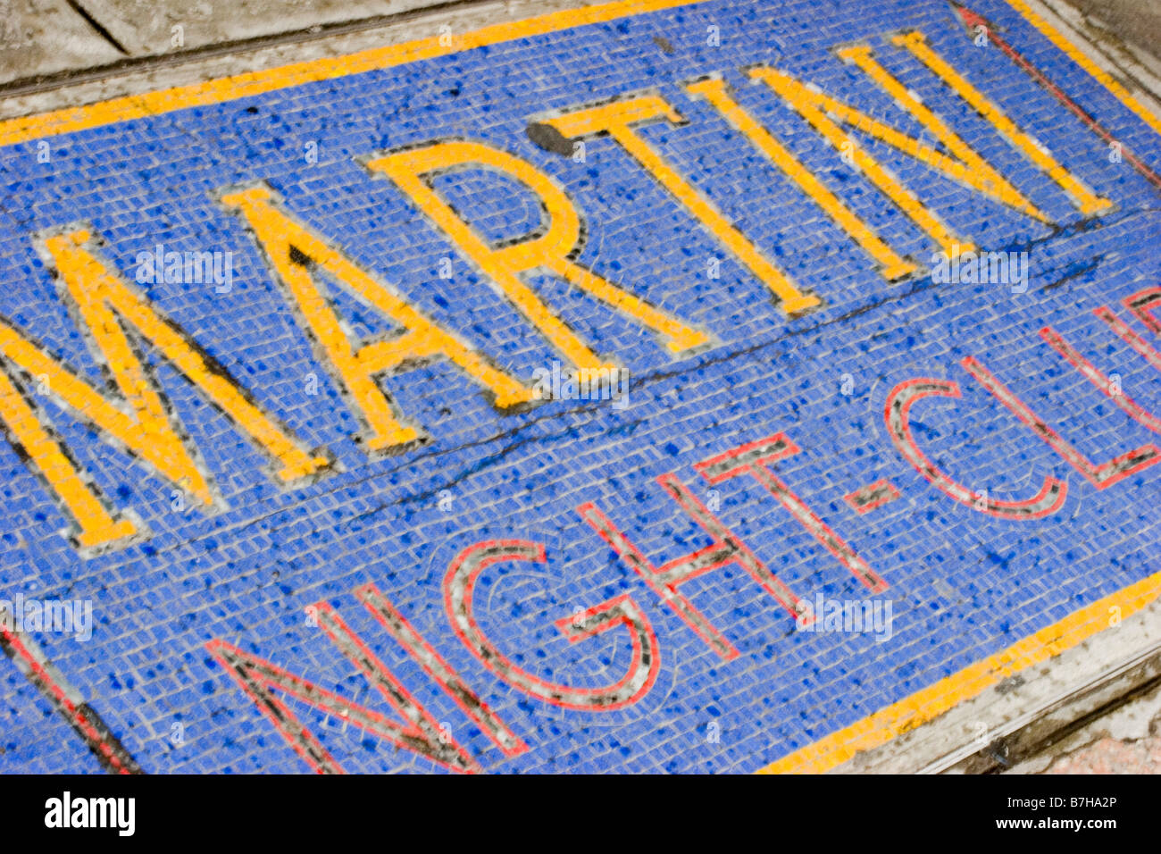 A colorful tiled sign on the ground for the Martini Night Club in