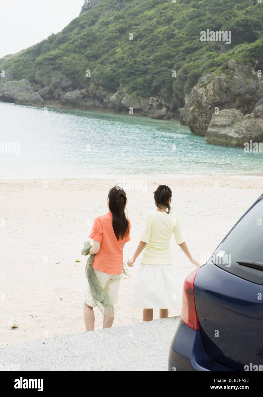 Two women taking a walk on a beach Stock Photo - Alamy