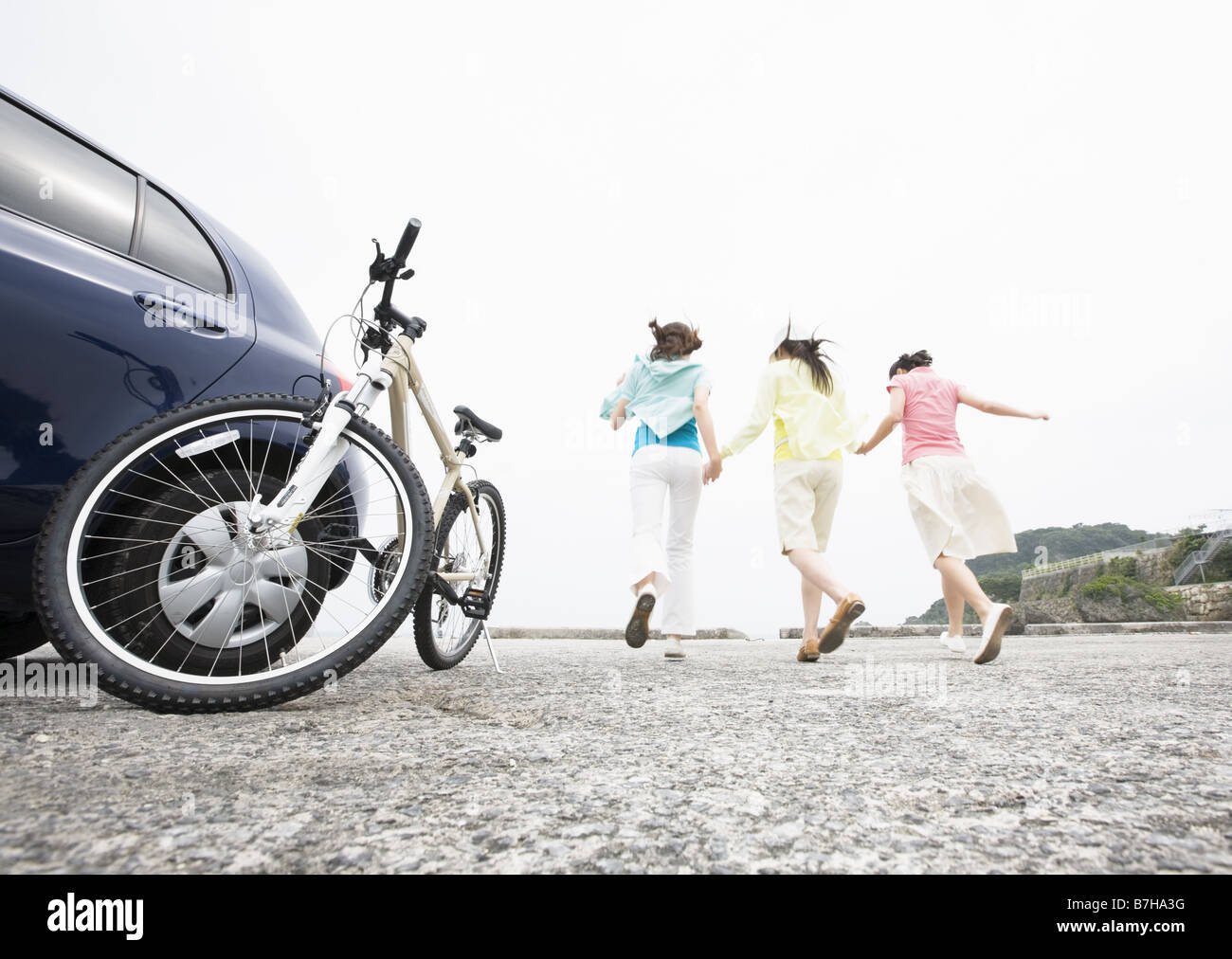 Three women running with holding hands Stock Photo - Alamy