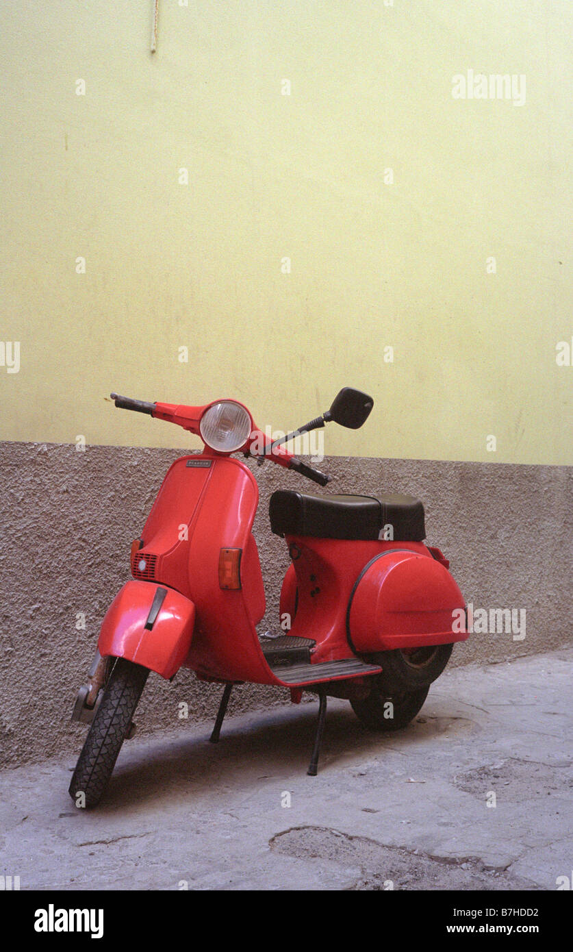 Red moped parked in a side street, Bosa, Sardinia, Italy. Stock Photo
