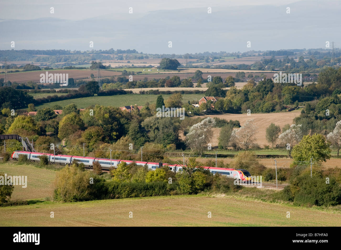 Class 390 Pendolino train in Virgin livery speeding through the english countryside on the West Coast Main Line England Stock Photo