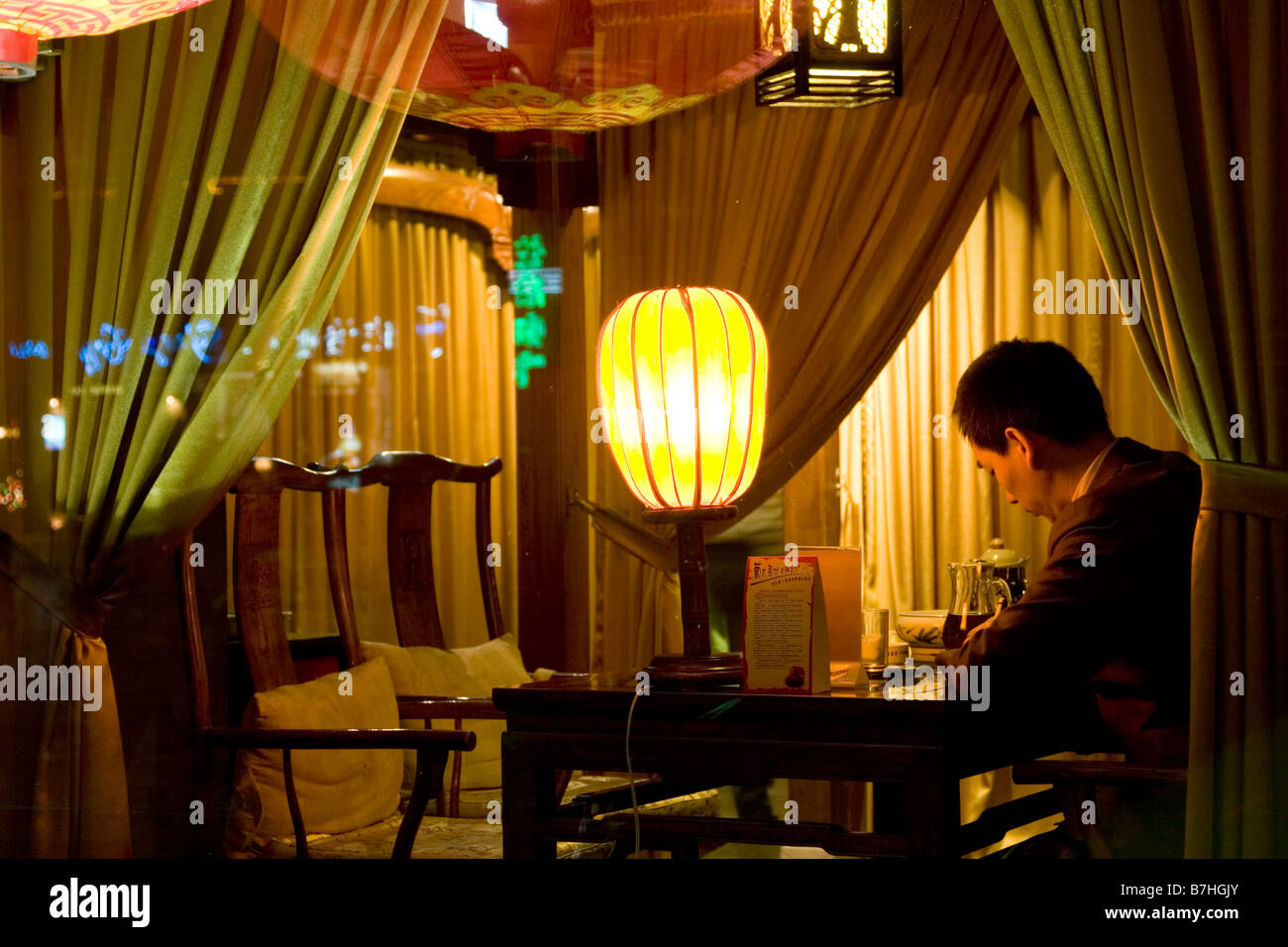 A man in a private booth in a modern teahouse in China. Stock Photo
