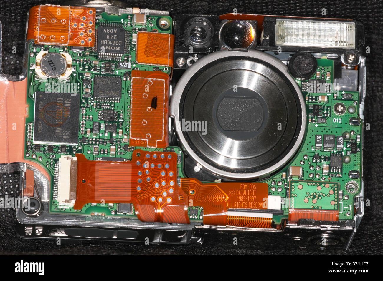 The main circuit board in a digital camera with lens assembly on the right. Stock Photo