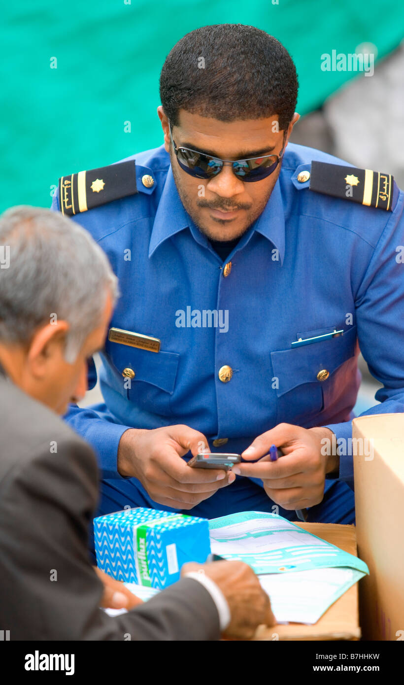 policeman Controlling  goods in the docks of Dubai UAE Stock Photo
