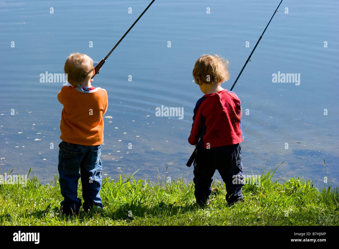 Two young boys fishing in a pond during a fishing derby Stock
