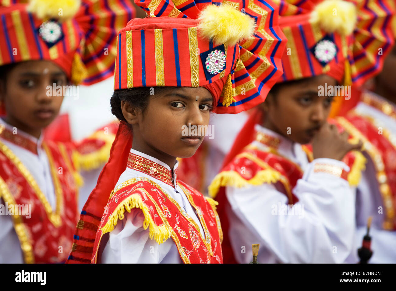 Colourful costumes of Indian Girls in a marching band in a street pageant in the town of Puttaparthi, India Stock Photo