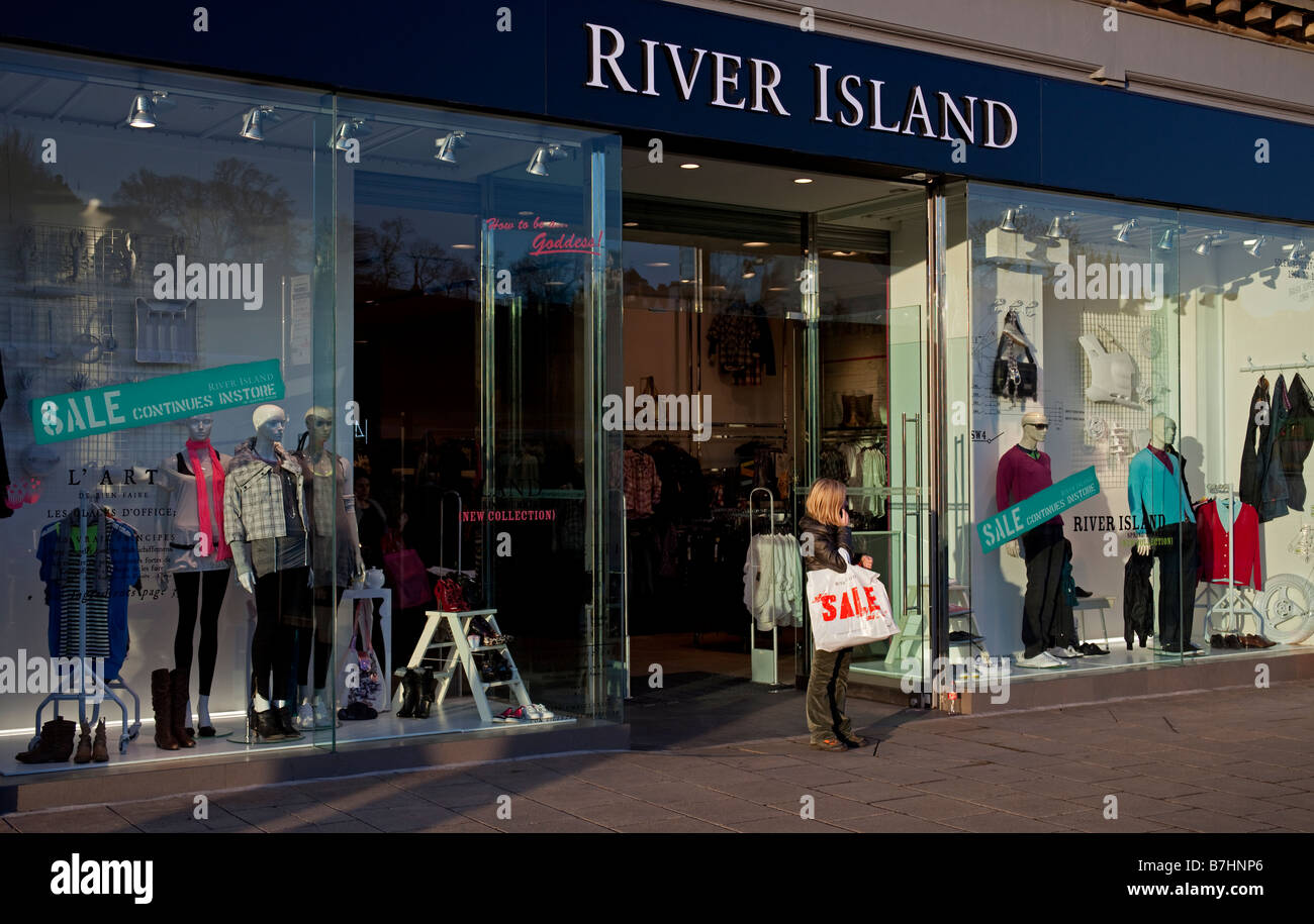 River Island store and female with sale plastic carrier shopping bag, Edinburgh, Scotland, UK, Europe Stock Photo