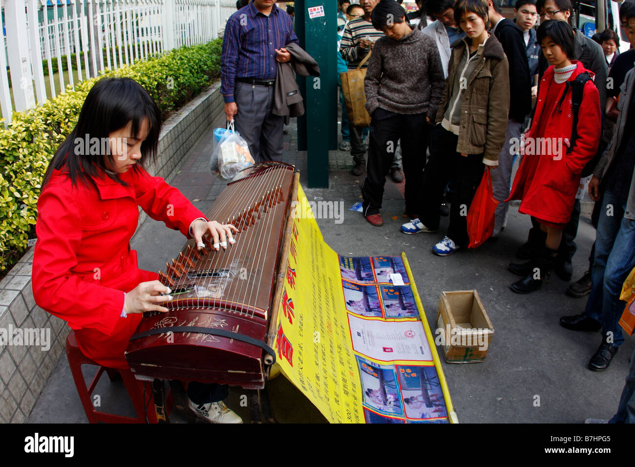 Teacher playing music on street in hopes to find private students as Chinese Economy worsens Stock Photo