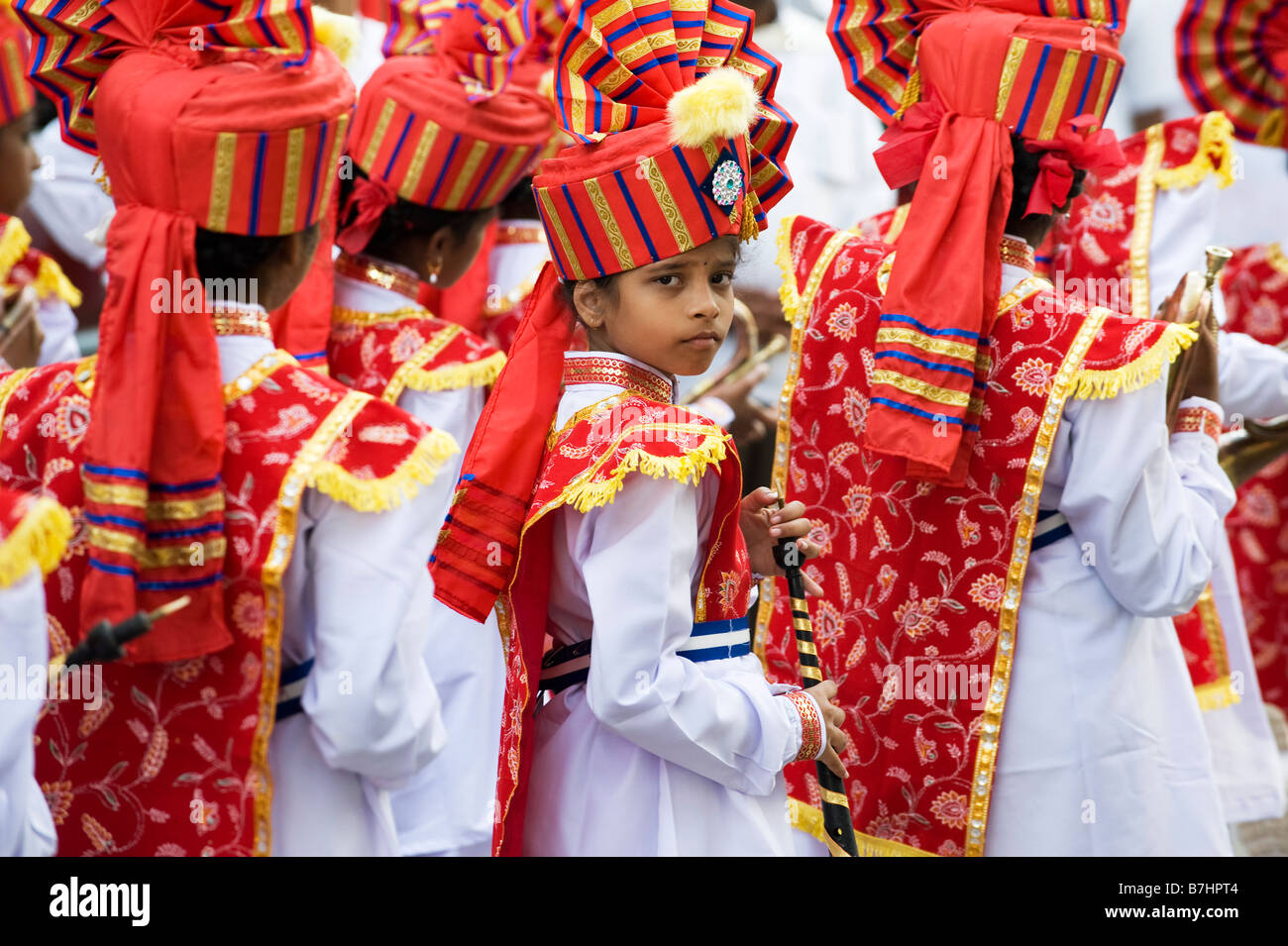 Colourful costumes of Indian Girls in a marching band in a street pageant in the town of Puttaparthi, Andhra Pradesh, India Stock Photo