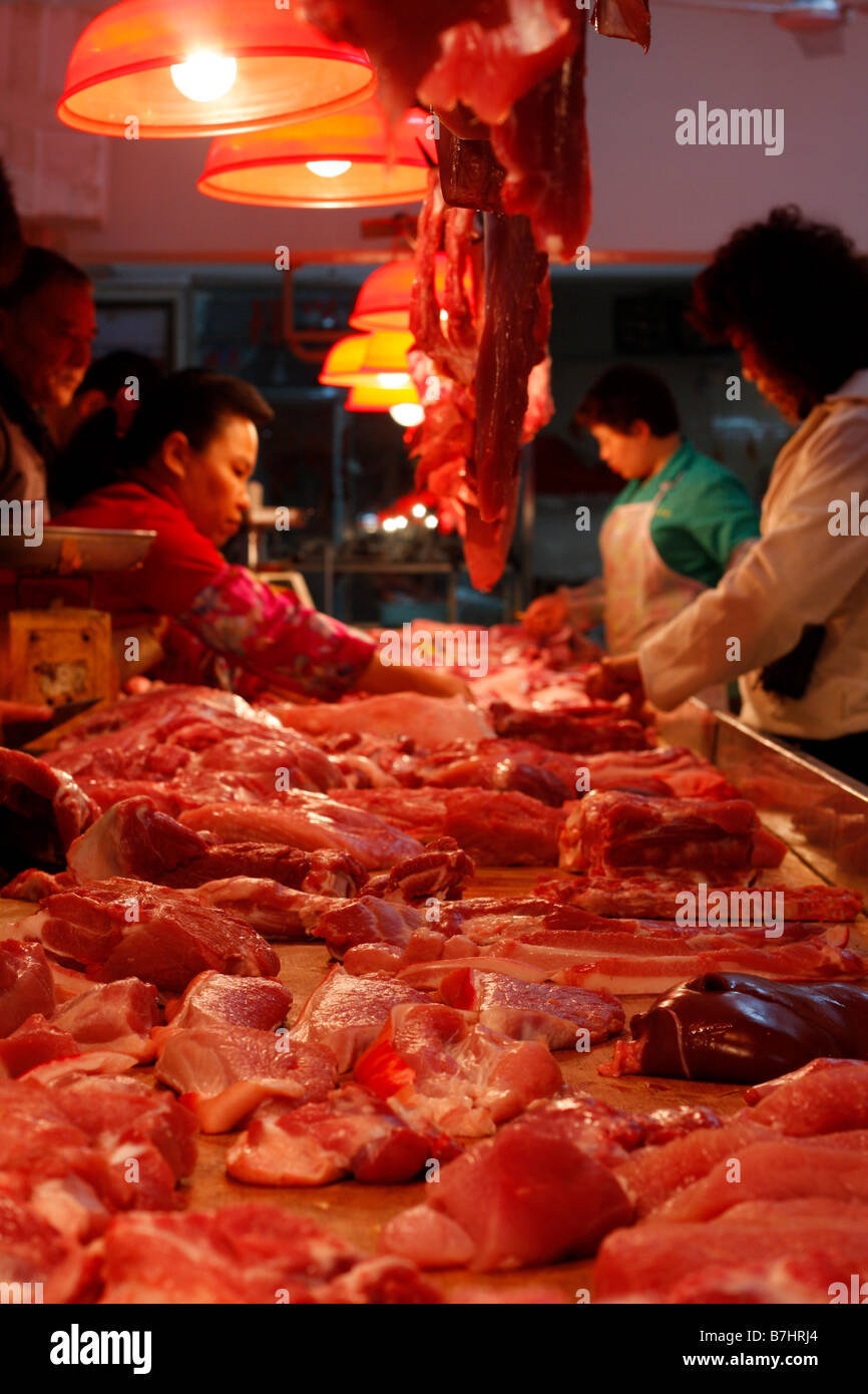 Chinese Butchers cutting meat in local market Stock Photo