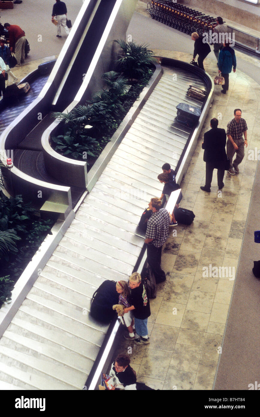 Passengers wait for luggage at carousel at John Wayne airport, Santa