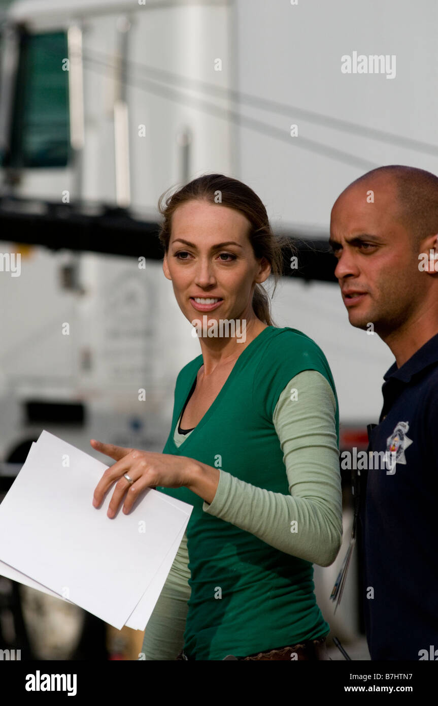 Extreme Home Makeover designer talks with show security person Stock Photo