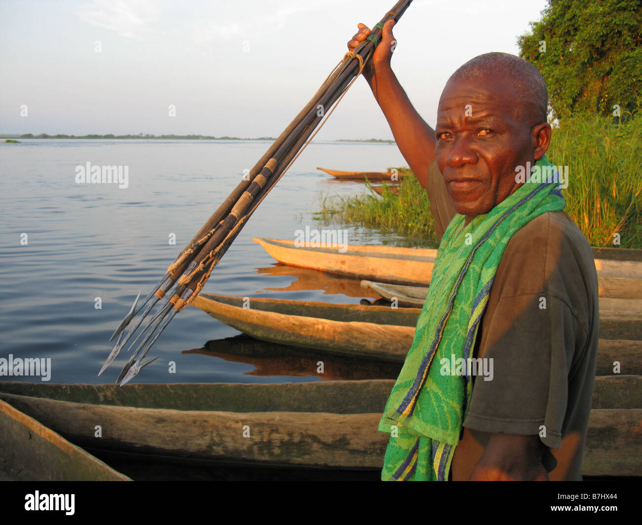 Congo River fisherman in dugout canoe with harpoon spears 