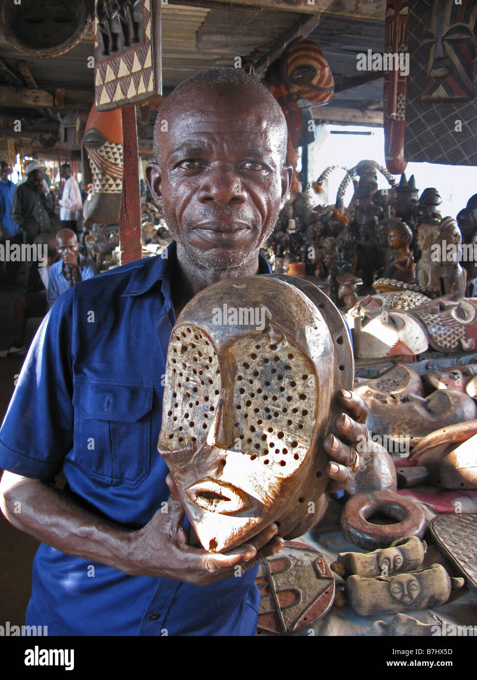 Elderly African man selling Congolese traditional masks in Old antiques market in Kinshasa Democratic Republic of Congo Stock Photo