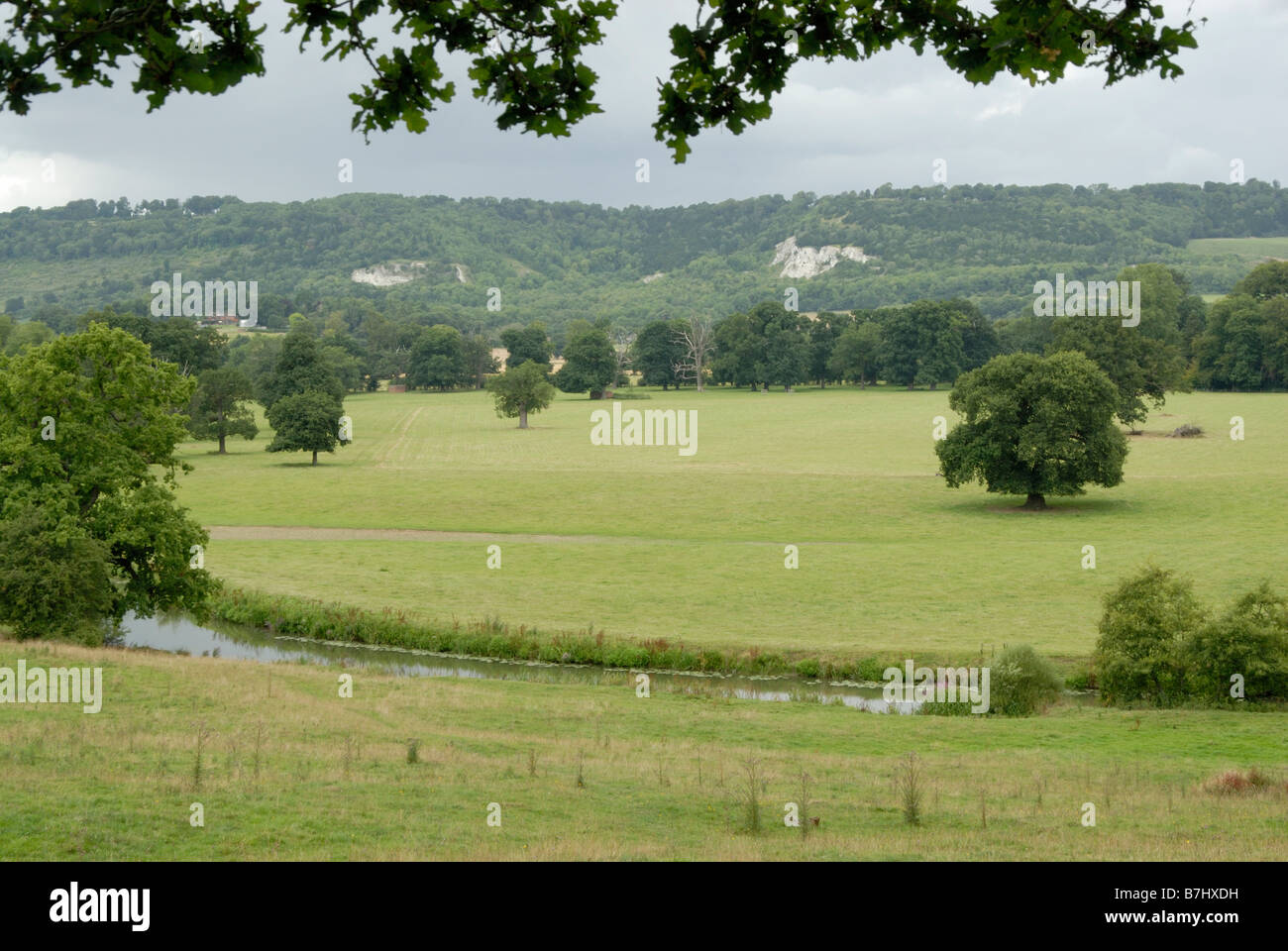 The River Mole running through trim pastures with misty North Downs in the distance, near Reigate, Surrey, England Stock Photo