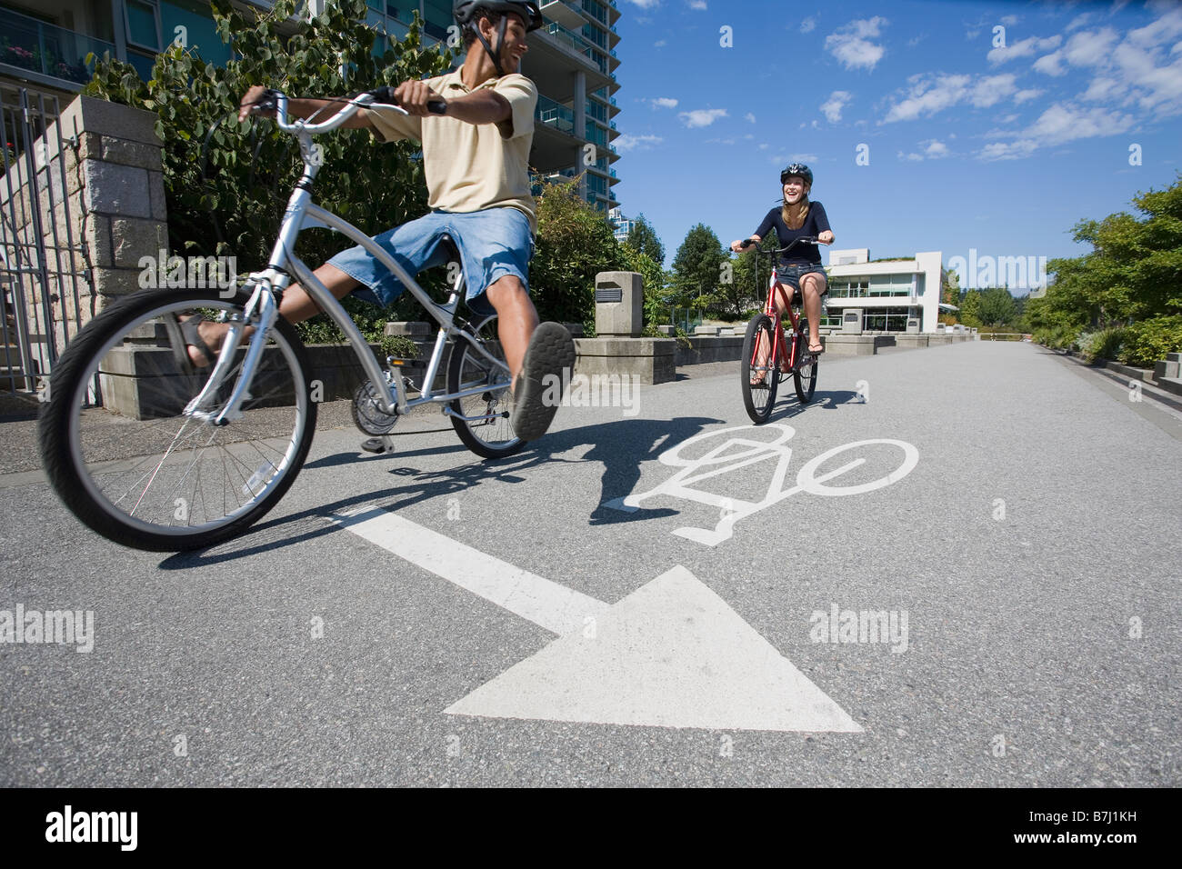 Young Couple Ride Bicycles on city bike path, Vancouver, British
