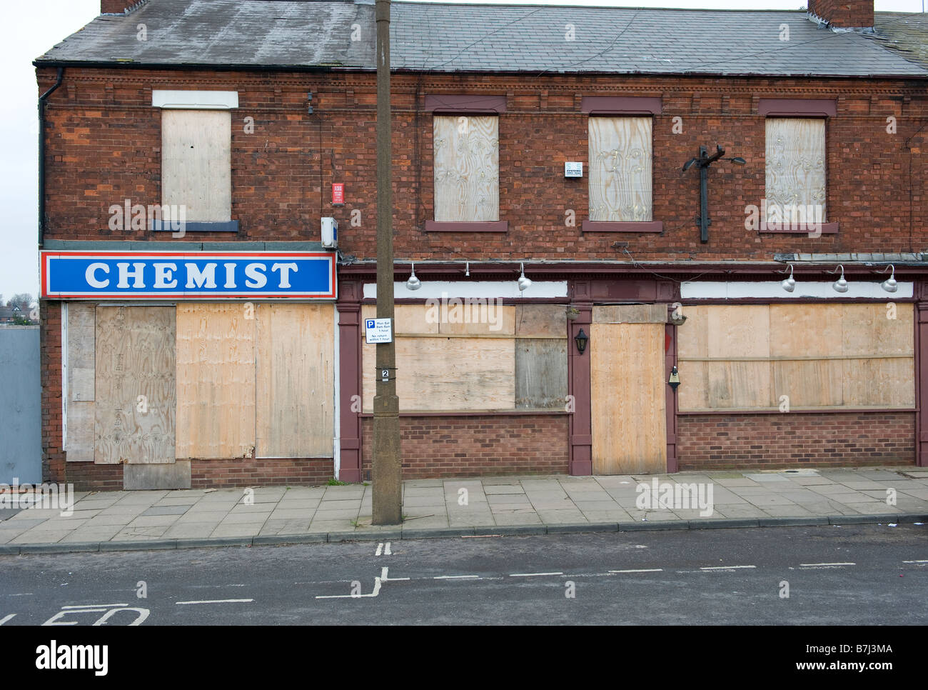 A boarded up row of empty and derelict shops in West Bromwich, West Midlands, England UK Stock Photo