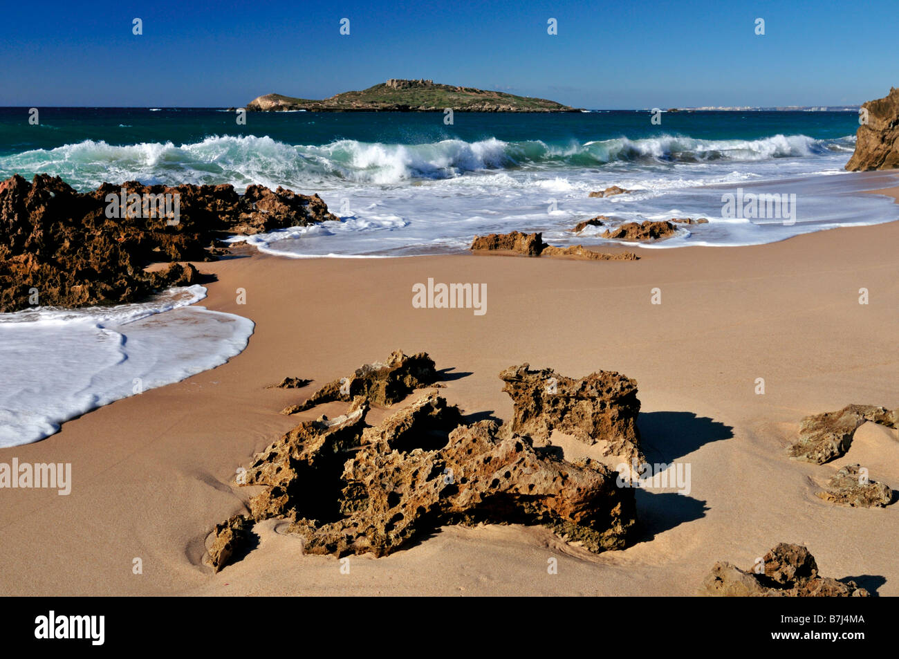 Rocks and waves at the beach of Porto Covo with view to Pessegueiro Island Stock Photo