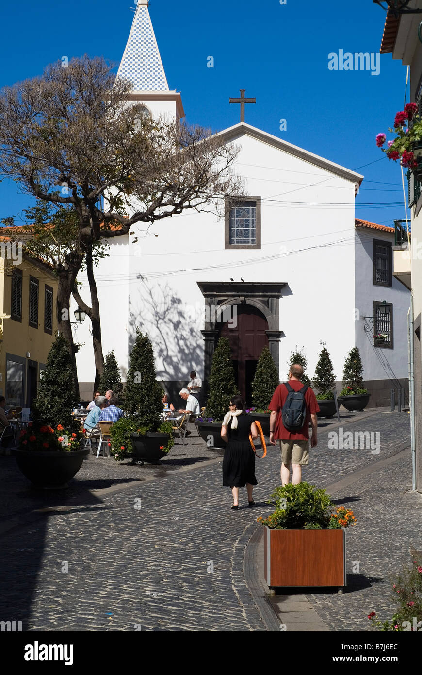 dh  CAMARA DE LOBOS MADEIRA Tourist couple walking through cobblestone street and village church tourists streets Stock Photo