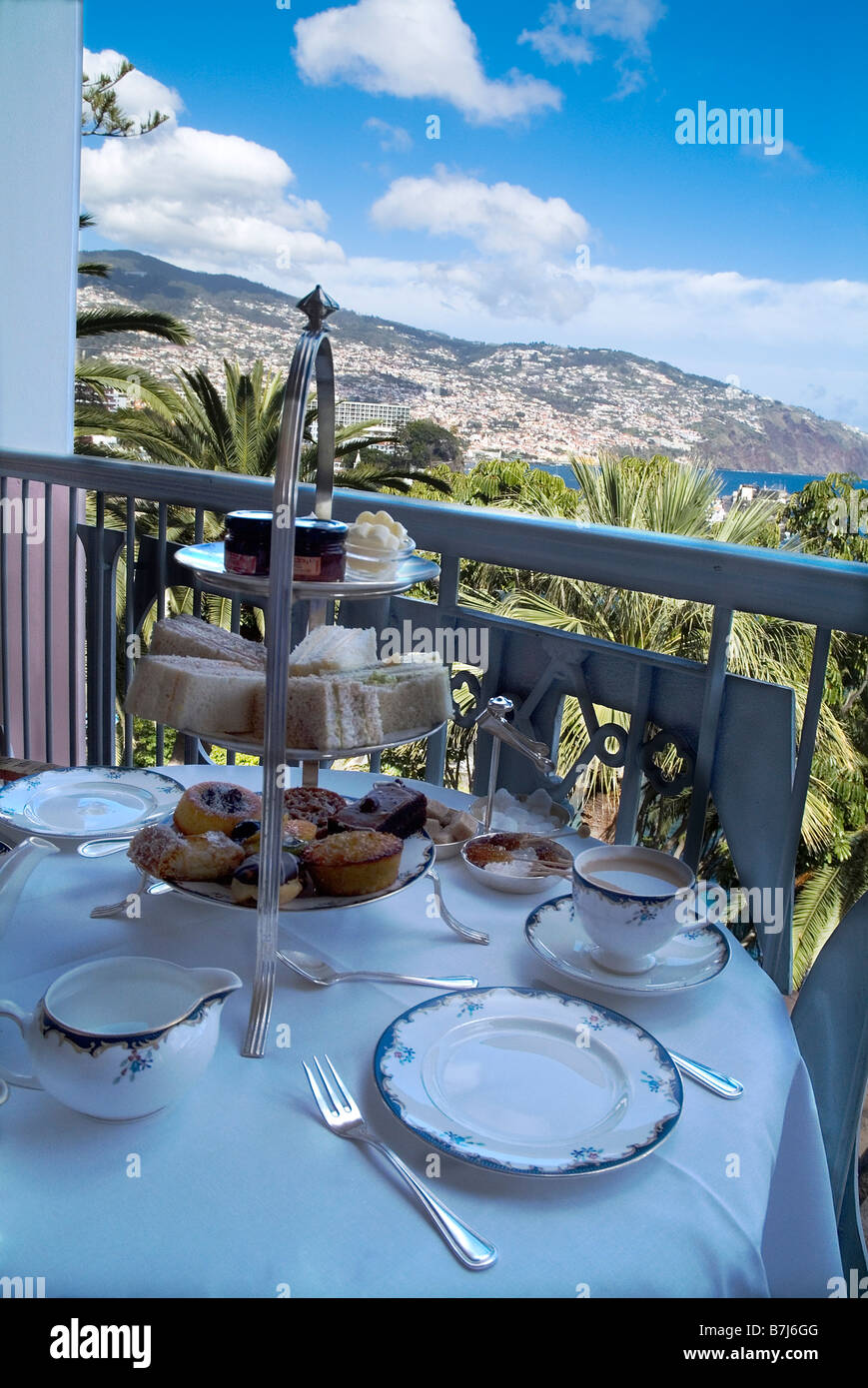 dh Reids Hotel hightea FUNCHAL HOTELS MADEIRA PORTUGAL Afternoon high tea table setting cakes food on balcony sandwiches with cake Stock Photo