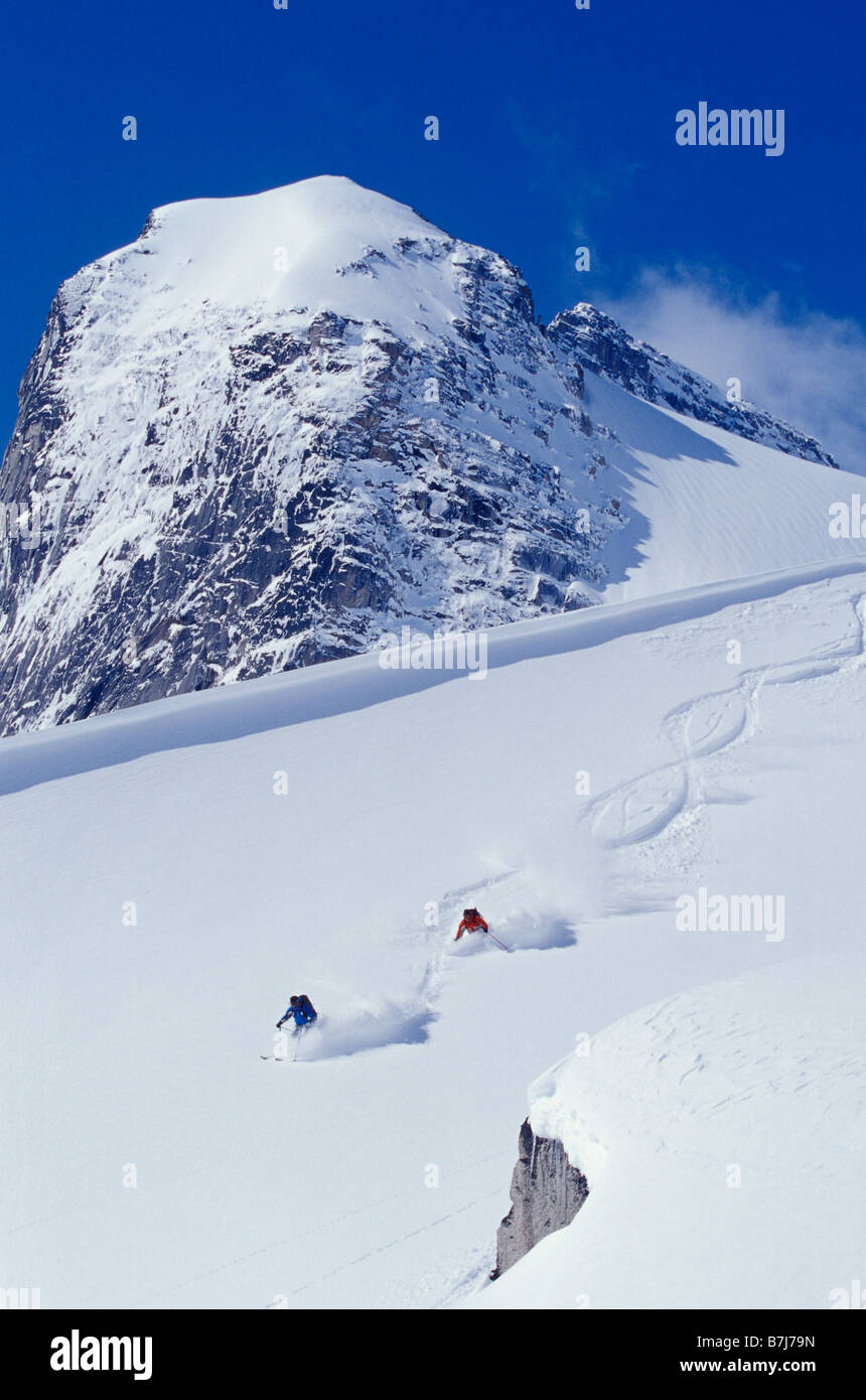 Two young men skiing untracked powder in figure 8's, Bugaboo Glacier Provincial Park, British Columbia, Canada Stock Photo