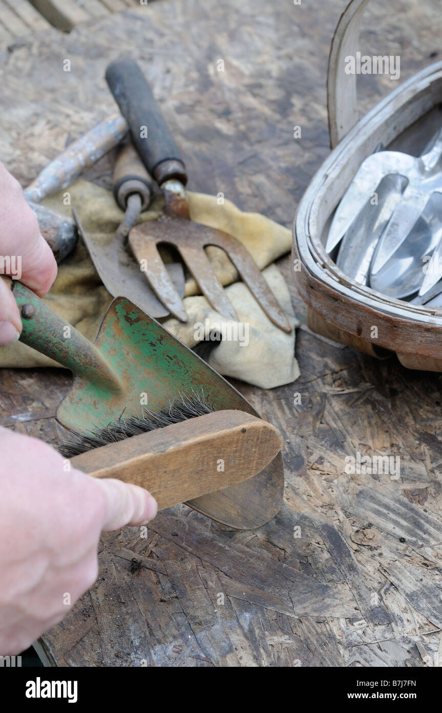 Cleaning gardening hand tools with wire brush Stock Photo