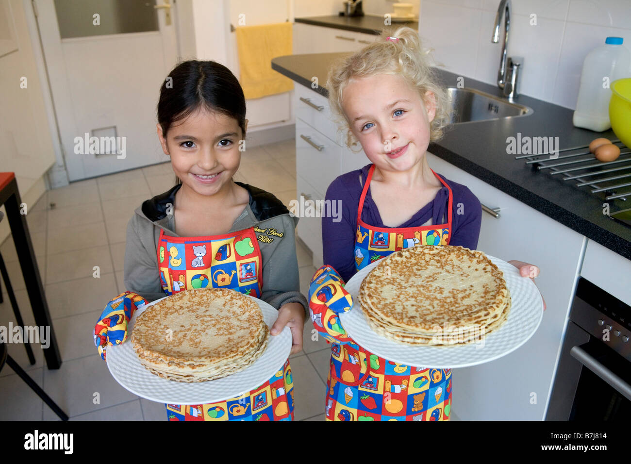 Two girls with self made pancakes Stock Photo