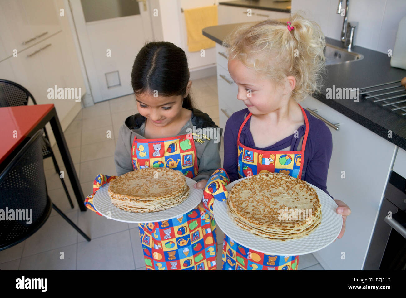 Two girls with self made pancakes Stock Photo