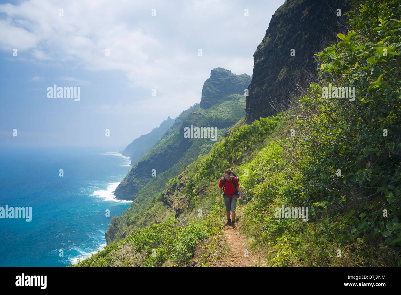 Hiker on the Kalalau Trail Na Pali Coast National Park Kaua i Hawaii USA Stock Photo