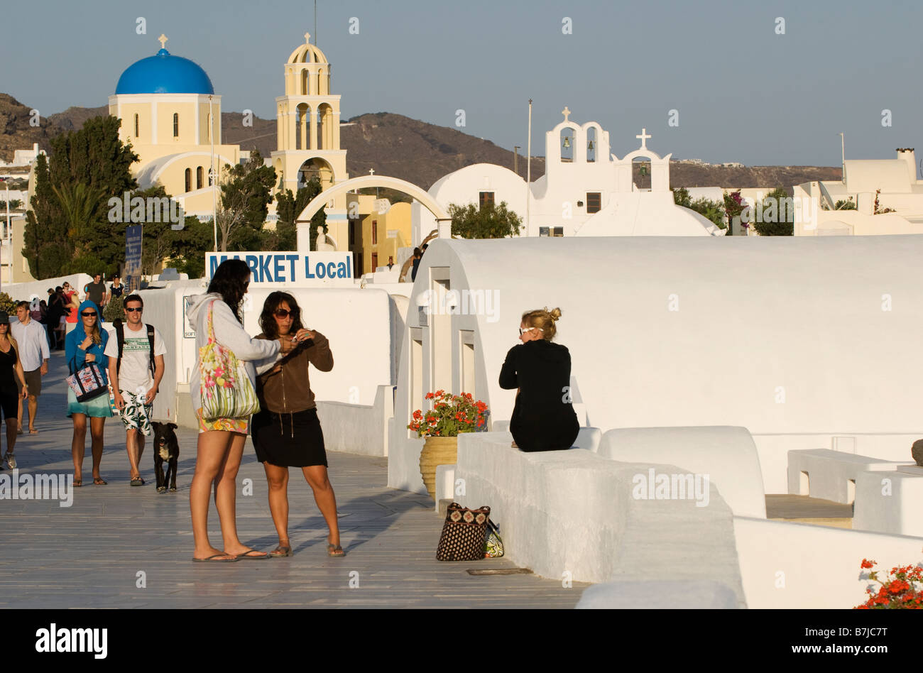 Tourists & travellers near one of several churches in the town of Oia, Santorini, Greece Stock Photo