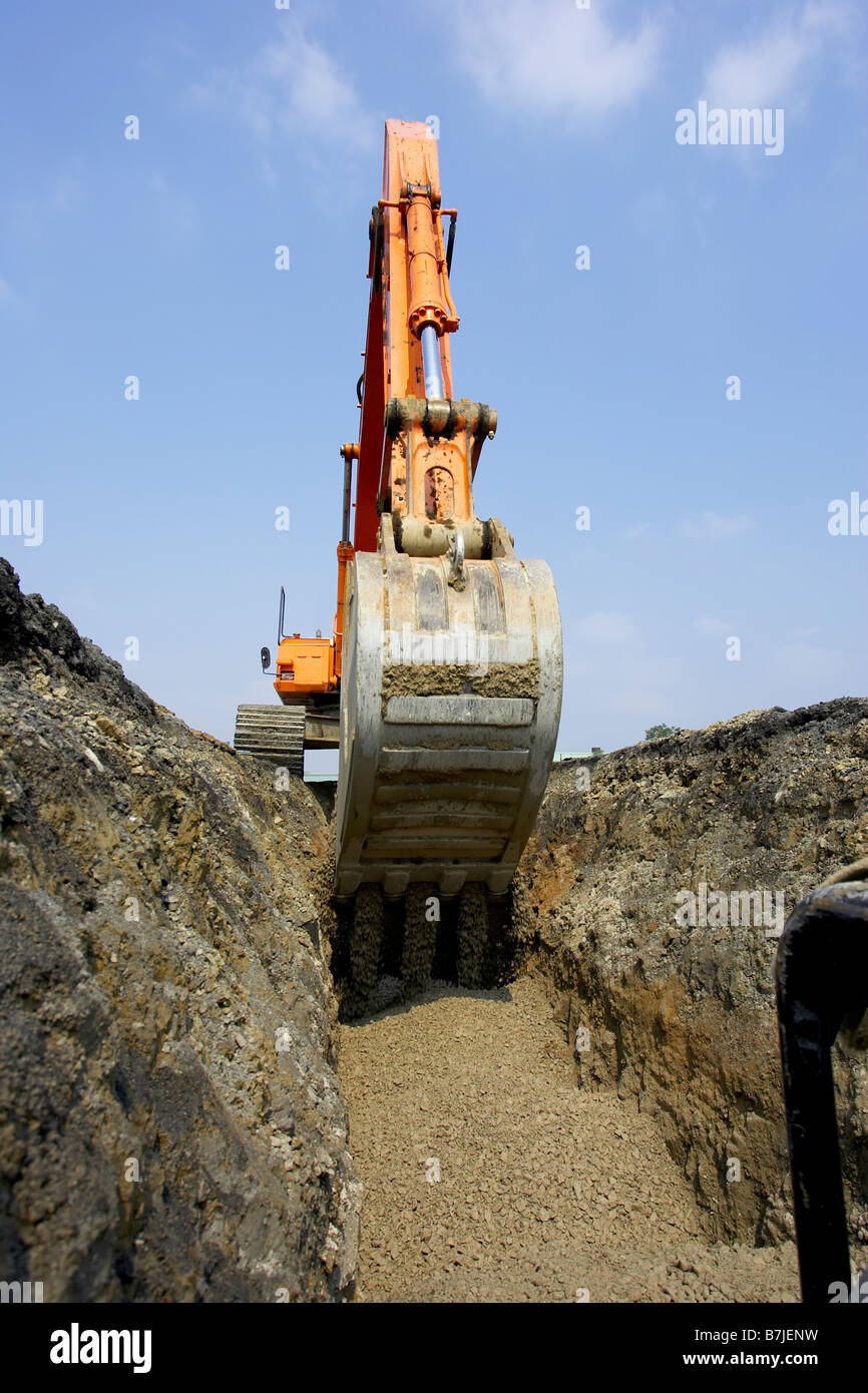 Excavator filling in section of drainage pipe with dirt; Canada