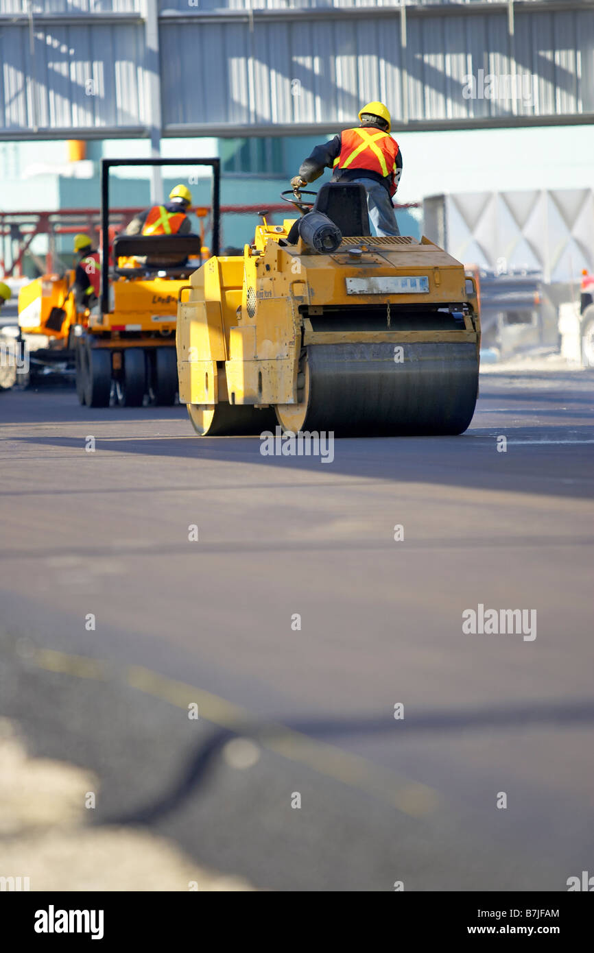 Steam rollers paving new asphalt; Canada, Ontario, Hamilton