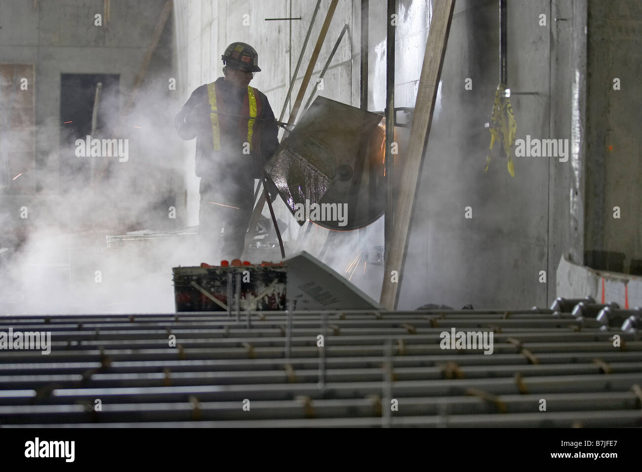 Worker cutting opening in concrete wall; Canada, Ontario, Hamilton