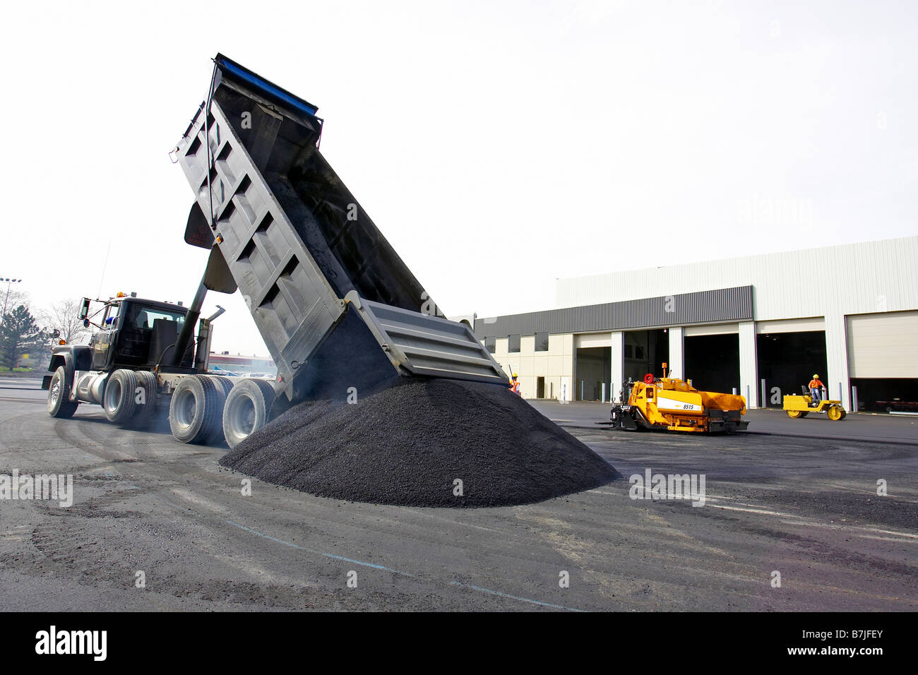 Dump truck dumping a pile of hot asphalt ; Canada, Ontario, Hamilton