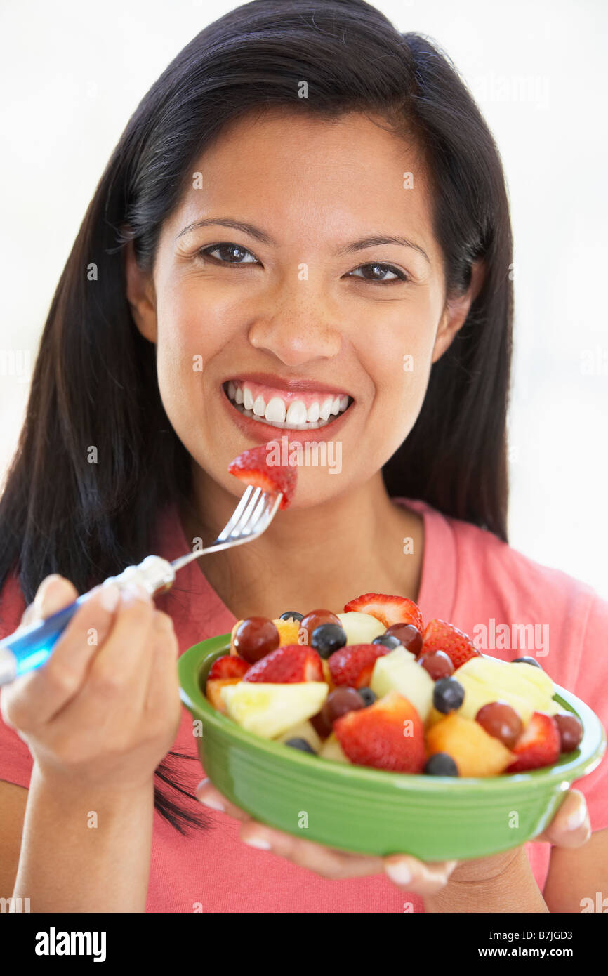 Mid Adult Woman Eating Fresh Fruit Salad Stock Photo